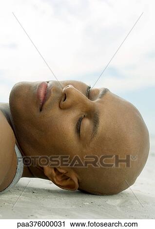 Man lying on sand with eyes closed, close-up of head View Large Photo Image Stock Image - Man lying on sand with eyes closed, close-up of head. Fotosearch