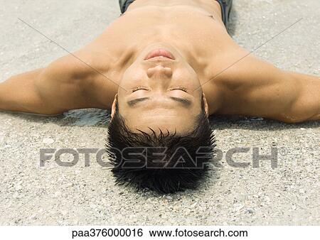Man lying on wet sand View Large Photo Image Stock Photograph - Man lying on wet sand. Fotosearch