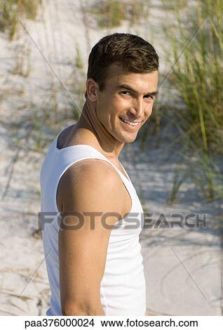 Man on beach, smiling at camera View Large Photo Image Picture - Man on beach, smiling at camera. Fotosearch