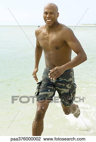 Man running through surf View Large Photo Image Stock Image - Man running through surf. Fotosearch