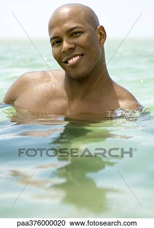 Man wading in sea, smiling View Large Photo Image Stock Image - Man wading in sea, smiling. Fotosearch