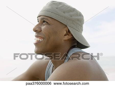Man wearing cap backwards, laughing View Large Photo Image Stock Photograph - Man wearing cap backwards, laughing. Fotosearch