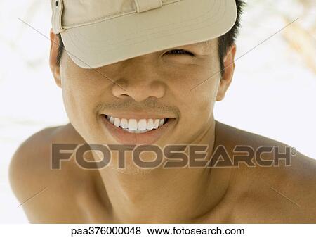 Man wearing cap tilted over eye View Large Photo Image Stock Photo - Man wearing cap tilted over eye. Fotosearch