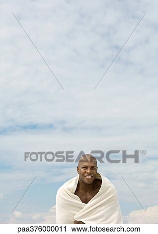 Man wrapped in towel, sky in background View Large Photo Image Stock Image - Man wrapped in towel, sky in background. Fotosearch