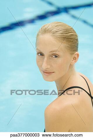Woman by pool, looking over shoulder, smiling at camera View Large Photo Image Stock Image - Woman by pool, looking over shoulder, smiling at camera. Fotosearch