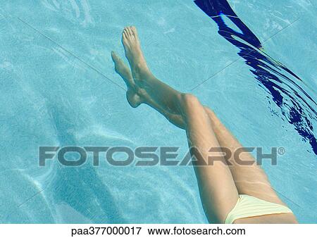 Woman floating in pool, view from waist down View Large Photo Image Stock Photo - Woman floating in pool, view from waist down. Fotosearch