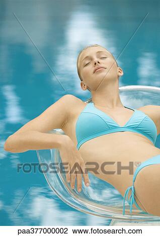 Woman lounging in chair by pool View Large Photo Image Stock Image - Woman lounging in chair by pool. Fotosearch