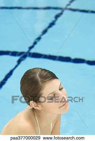Woman near pool, eyes closed and smiling View Large Photo Image Stock Photo - Woman near pool, eyes closed and smiling. Fotosearch