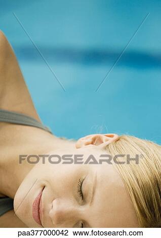 Woman reclining by pool, close-up of face View Large Photo Image Stock Image - Woman reclining by pool, close-up of face. Fotosearch
