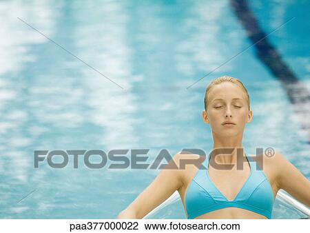 Woman relaxing near pool, eyes closed View Large Photo Image Stock Image - Woman relaxing near pool, eyes closed. Fotosearch