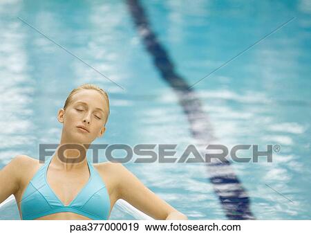 Woman relaxing near pool with eyes closed View Large Photo Image Stock Photo - Woman relaxing near pool with eyes closed. Fotosearch