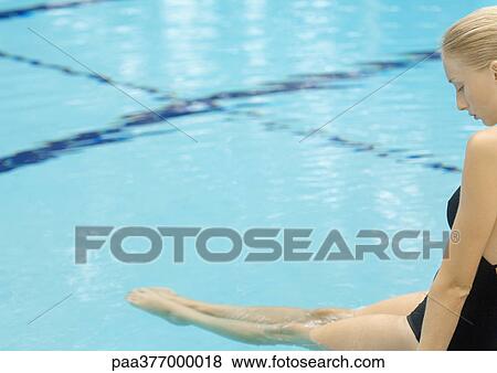 Woman sitting on edge of pool with legs in water View Large Photo Image Stock Photo - Woman sitting on edge of pool with legs in water. Fotosearch