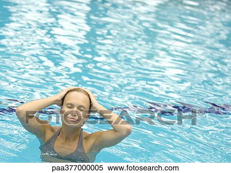 Woman standing in pool with hands on head and eyes closed View Large Photo Image Stock Photography - Woman standing in pool with hands on head and eyes closed. Fotosearch