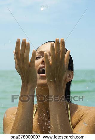 Woman in water splashing in water, eyes closed View Large Photo Image Stock Photo - Woman in water splashing in water, eyes closed. Fotosearch