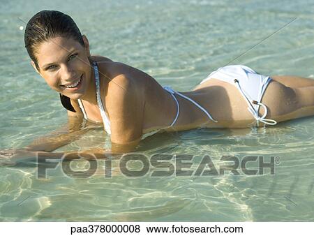 Woman lying in shallow water on beach View Large Photo Image Stock Photo - Woman lying in shallow water on beach. Fotosearch