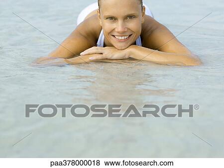Woman lying in shallow water on beach View Large Photo Image Stock Photo - Woman lying in shallow water on beach. Fotosearch
