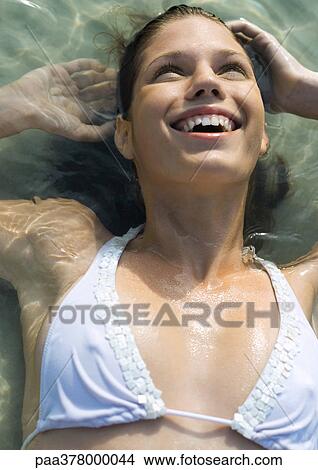 Woman lying in shallow water, smiling View Large Photo Image Picture - Woman lying in shallow water, smiling. Fotosearch