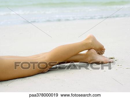 Woman lying on sand, view of legs View Large Photo Image Stock Photo - Woman lying on sand, view of legs. Fotosearch