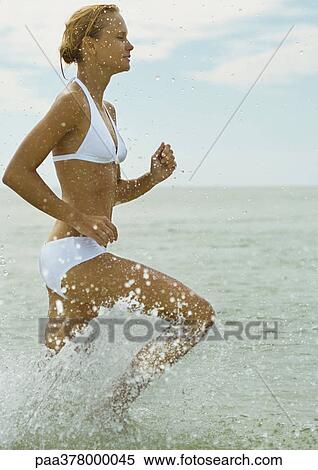 Woman running in surf, side view View Large Photo Image Stock Photography - Woman running in surf, side view. Fotosearch