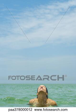 Woman standing in sea, head back and eyes closed View Large Photo Image Stock Image - Woman standing in sea, head back and eyes closed. Fotosearch