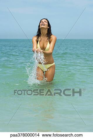 Woman standing in sea, splashing View Large Photo Image Picture - Woman standing in sea, splashing. Fotosearch