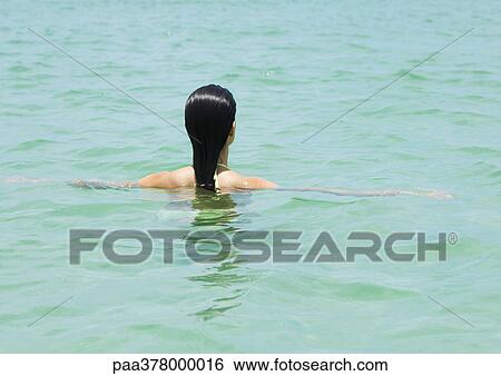 Woman wading in sea, rear view View Large Photo Image Stock Photograph - Woman wading in sea, rear view. Fotosearch