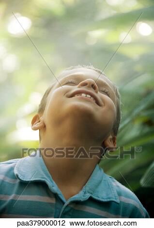 Boy smiling with head back in mist View Large Photo Image Stock Image - Boy smiling with head back in mist. Fotosearch