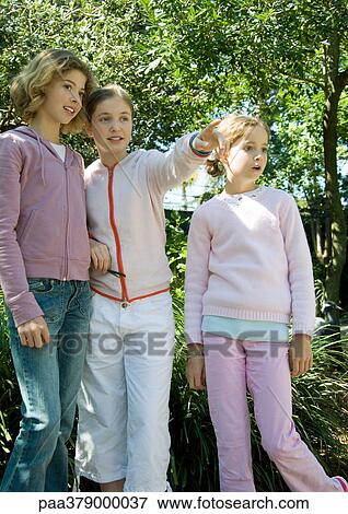 Group of girls, one pointing View Large Photo Image Stock Photo - Group of girls, one pointing. Fotosearch