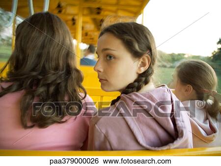 Preteen girls riding train in amusement park, rear view View Large Photo Image Stock Photograph - Preteen girls riding train in amusement park, rear view. Fotosearch