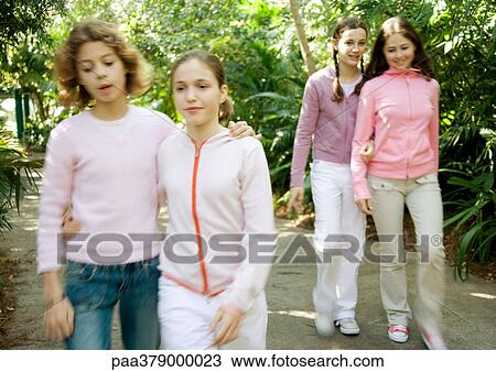 Stock Image - Preteen girls walking on path. Fotosearch