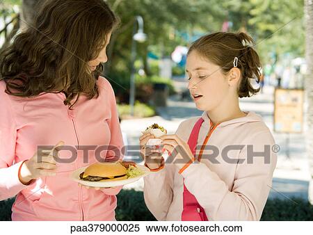 Two preteen girls eating junk food View Large Photo Image Stock Photography - Two preteen girls eating junk food. Fotosearch