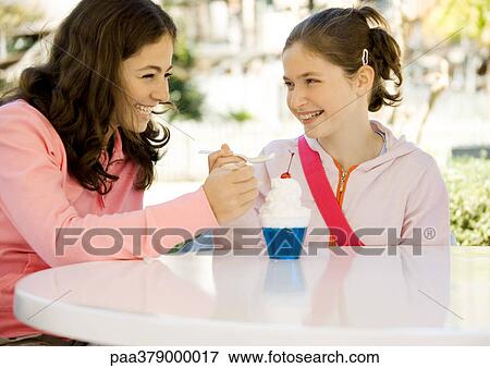 Two preteen girls sharing dessert View Large Photo Image Stock Photo - Two preteen girls sharing dessert. Fotosearch