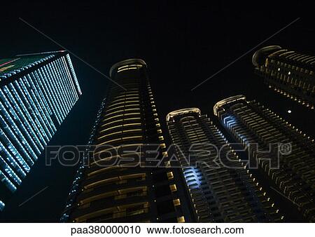 Stock Image - Skycrapers at night, low angle view. Fotosearch