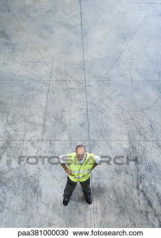 Factory worker standing with hands on hips, high angle view View Large Photo Image Stock Image - Factory worker standing with hands on hips, high angle view. Fotosearch
