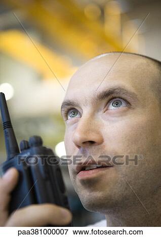 Stock Photo - Factory worker using walkie-talkie. Fotosearch