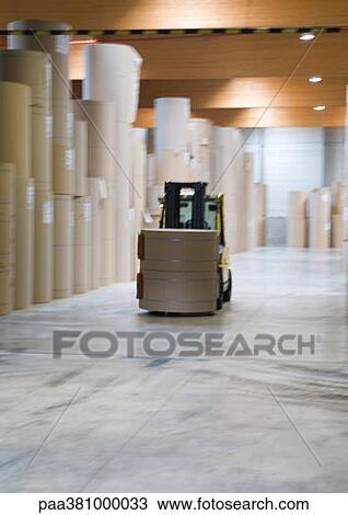 Stock Image - Forklift transporting roll of paper in warehouse. Fotosearch