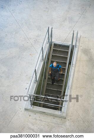 Man going down stairs, high angle view View Large Photo Image Stock Image - Man going down stairs, high angle view. Fotosearch