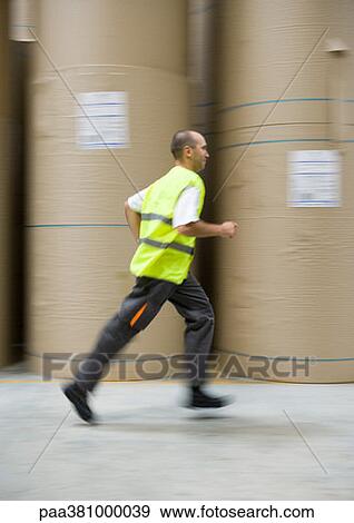 Man running past rolls of paper in warehouse View Large Photo Image Stock Photo - Man running past rolls of paper in warehouse. Fotosearch