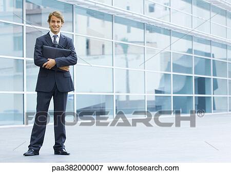 Stock Photo - Businessman holding briefcase, full length portrait. Fotosearch