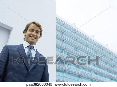 Businessman, portrait, standing in front of office building View Large Photo Image Stock Photography - Businessman, portrait, standing in front of office building. Fotosearch