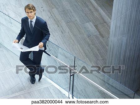 Businessman reading newspaper, high angle view View Large Photo Image Picture - Businessman reading newspaper, high angle view. Fotosearch