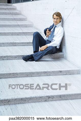 Businessman sitting on steps, smiling View Large Photo Image Stock Photography - Businessman sitting on steps, smiling. Fotosearch