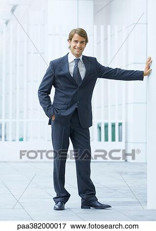 Businessman standing with hand in pocket, full length View Large Photo Image Stock Photo - Businessman standing with hand in pocket, full length. Fotosearch