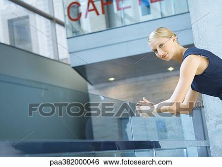 Businesswoman, leaning arms on rail, looking at camera View Large Photo Image Stock Photograph - Businesswoman, leaning arms on rail, looking at camera. Fotosearch