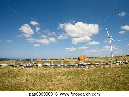 Wind turbine in field with bales of hay, barbed wire in foreground View Large Photo Image Stock Image - Wind turbine in field with bales of hay, barbed wire in foreground. Fotosearch
