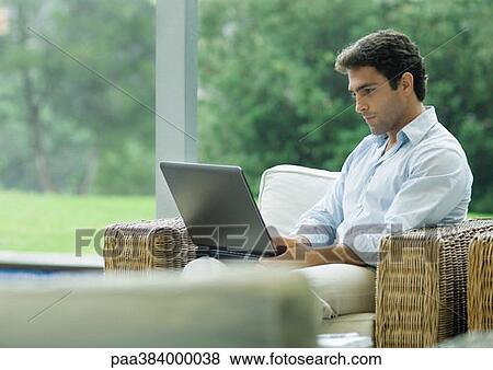 Casually dressed young executive working on laptop outdoors View Large Photo Image Stock Photo - Casually dressed young executive working on laptop outdoors. Fotosearch