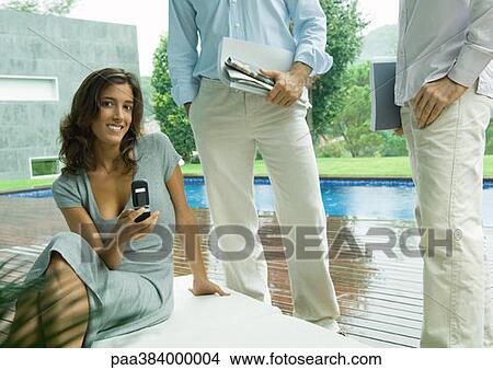 Picture - Casually dressed young executives working near edge of pool. Fotosearch