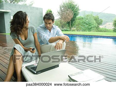 Picture - Casually dressed young executives working near edge of pool. Fotosearch