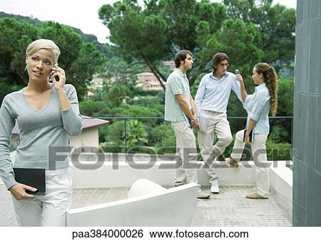 Stock Photograph - Casually dressed young executives working outdoors. Fotosearch