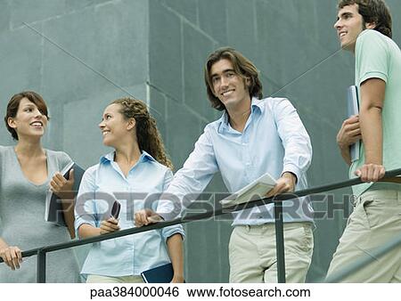 Casually dressed young executives standing next to railing, low angle view View Large Photo Image Stock Photograph - Casually dressed young executives standing next to railing, low angle view. Fotosearch